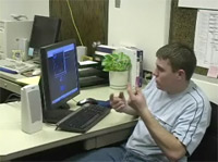 Foto de un estudiante con un ordenador utilizando la lengua de signos