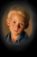 Una fotografía de un niño que está borrosa en el centro y los bordes están completamente oscurecidos debido a la pérdida de la visión periférica